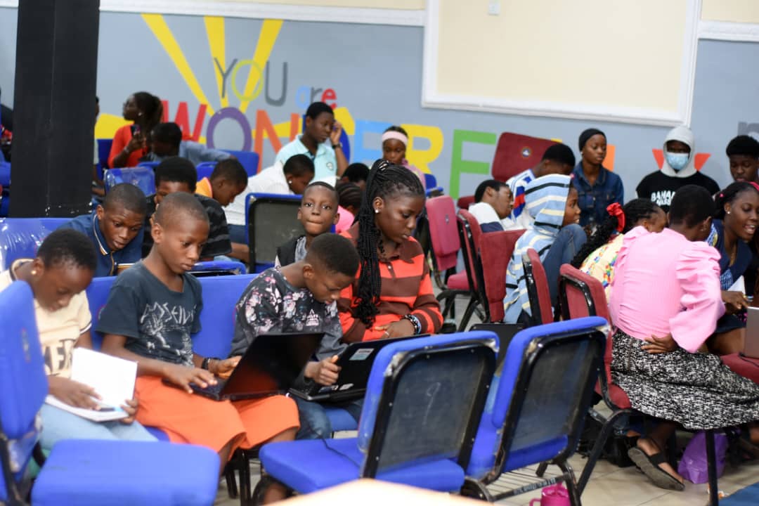 Young JENECONK learners using laptops and notes during practical AI bootcamp training